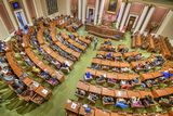 An aerial view of the House Chamber. Students sit at the members' desks and listen to Representative Noor, who is speaking in the center of the Chamber.
